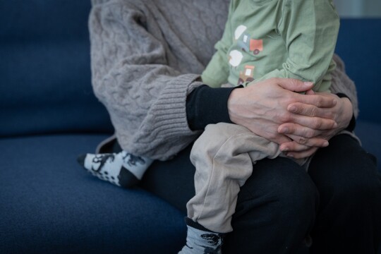 Pieni lapsi aikuisen sylissä