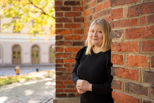 Ulla Moilanen tiilirakennuksen vieressä.