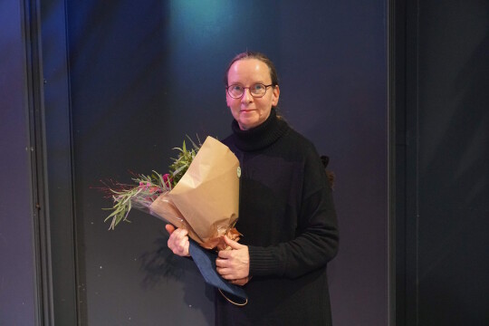 Maarit Wuorela poseeraamassa kukkien kera