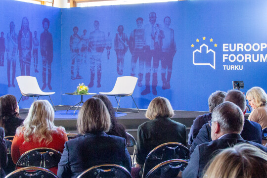Eurooppa-foorumin taustaseinä ja ihmisiä katsomossa.