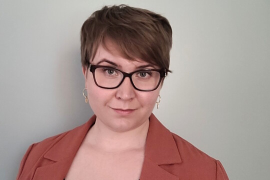 Lyhythiuksinen, silmälasipäinen nainen.