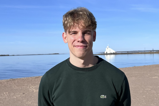 Konsta Koivunen lähikuvassa ulkona rannalla.