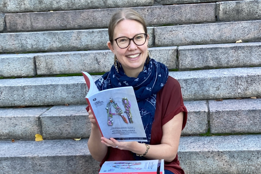 Kaisa Kukkonen selaa väitöskirjaansa.