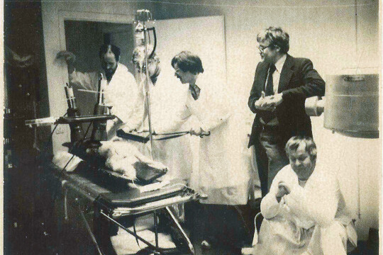 Mustavalkoinen kuva ihmisistä kuvantamislaitteen edessä