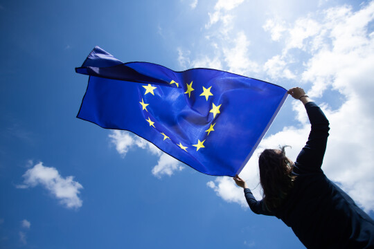 person holding and EU flag in wind