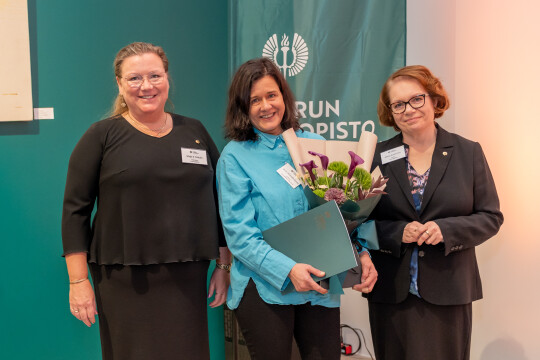 Rehtori Marjo Kaartinen (oikealla) ja vararehtori Maija S. Peltola (vasemmalla) jakoivat vuoden vaikuttavuustekotunnustuksen professori Anne Alvesalo-Kuuselle. 
