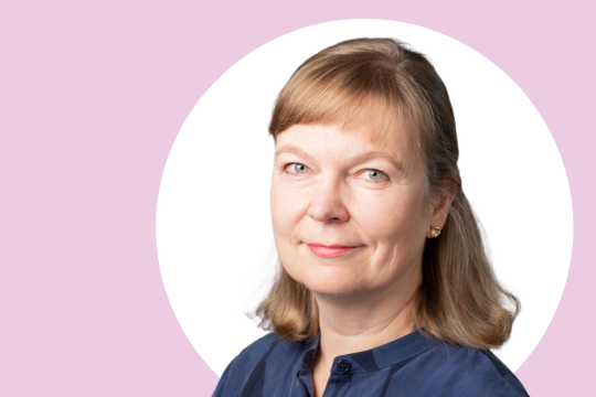 Sanna Aaltonen lähikuvassa, taustalla valkoista ja vaaleanpunaista.