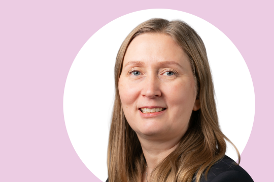Anne Quarshie lähikuvassa, taustalla vaaleanpunaista ja valkoista.