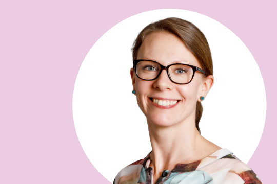 Nora Fagerholm lähikuvassa, taustalla vaaleanpunaista ja valkoista.