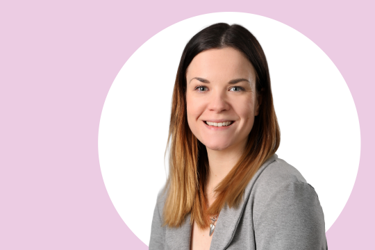 Iida Laine lähikuvassa, taustalla vaaleanpunaista ja valkoista.