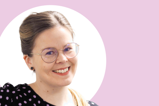 Susanna Likitalo lähikuvassa, vaaleanpunainen tausta.