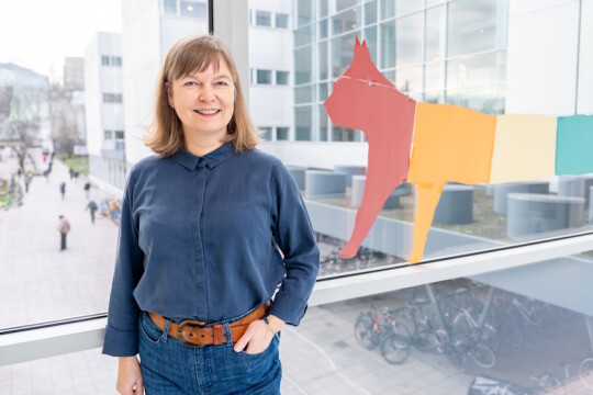 Nainen kuvattuna lasisessa käytävässä