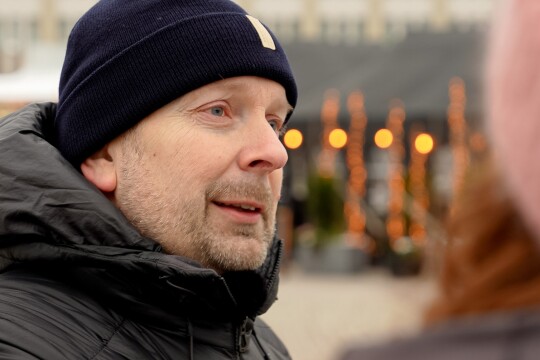 Tommi Kurki lähikuvassa kauppatorilla puhumassa henkilölle, jonka takaprofiili näkyy hieman.