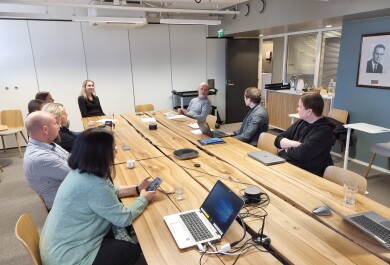 Ihmisiä pöydän ääressä keskustelemassa