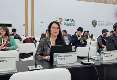 Researcher Caroline Fukushima attending the CoP20 meeting as an observer. Rows of people sitting in a conference room, Caroline pictured in the front row