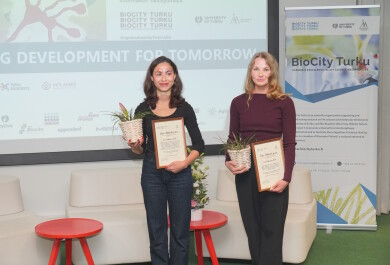 Palkitut poseeraamassa kasvin ja diplomin kanssa