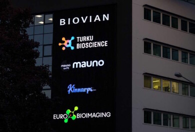 Pimeällä otettu kuva BioCityn seinän logoista, joissa myös Euro-BioImaging