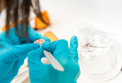 Henkilö työskentelee laboratoriossa, vain kädet näkyvät.