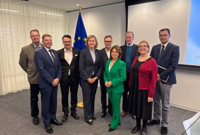 Nine people standing together looking at the camera.