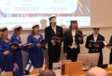 Turun yliopiston kuoro esiintymässä luentosalin edessä.