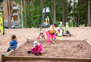 Taaperoikäisiä lapsia leikkimässä hiekkalaatikolla.