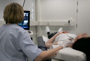 Hoitaja suorittaa potilaan kaulavaltimon ultraäänikuvantamista Väestötutkimuskeskuksen tiloissa.