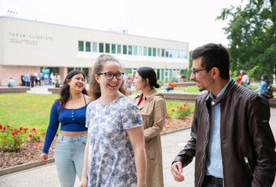 Four students walking together looking at each other