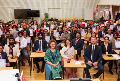A group of people sitting in a lecture hall holding their certificates.