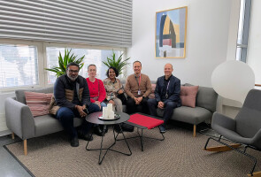 five people sitting on a couch looking at the camera