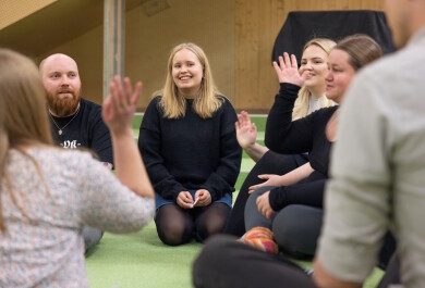 Ihmisiä istumassa lattialla keskustelemassa.