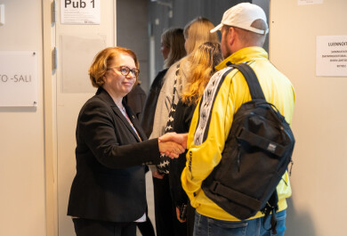 Rector Marjo Kaartinen shakes hands with a new student.