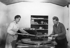 Kaksi henkilöä hioo tähtitornin korjauslasia tunnelihiomossa 50-luvulla