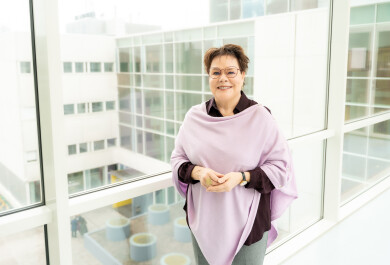 Benita Heiskanen lähikuvassa, taustalla olevasta ikkunasta näkyy Turun alakampusta.