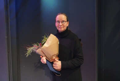 Maarit Wuorela poseeraamassa kukkien kera