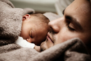 Isä nukkuu vauva rintakehällään.