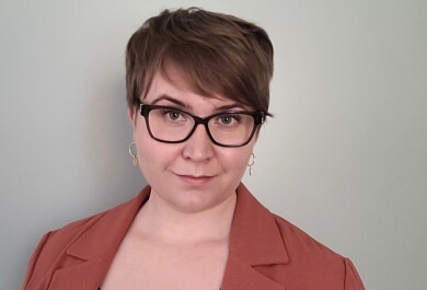 Lyhythiuksinen, silmälasipäinen nainen.