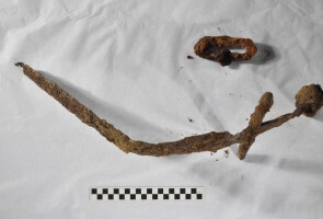 Maalämpöputkikaivannosta löytynyt ristiretkiaikainen miekka ja miekan huotraan kuulunut osa.
