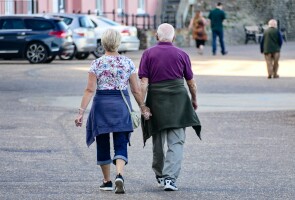 Kaksi ikäihmistä kävelee kadulla.