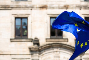 Liehuva EU:n lippu taustallaan vanhan rakennuksen ikkunarivi