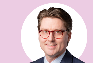 Tuomas Kiviniemi lähikuvassa, taustalla vaaleanpunaista ja valkoista.