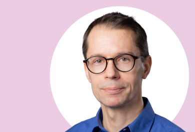 Pekka Laukkanen lähikuvassa, taustalla valkoista ja vaaleanpunaista.