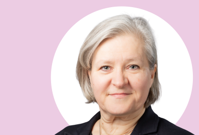 Kirsi Virtanen lähikuvassa, taustalla vaaleanpunaista ja valkoista.