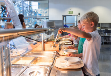 Lapsia kouluruokalan linjastolla ottamassa ruokaa