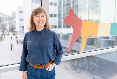 Nainen kuvattuna lasisessa käytävässä