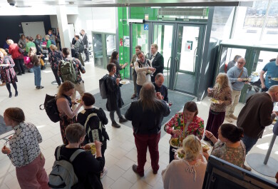 Ihmisiä seurustelemassa rakennuksen aulassa.