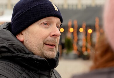 Tommi Kurki lähikuvassa kauppatorilla puhumassa henkilölle, jonka takaprofiili näkyy hieman.