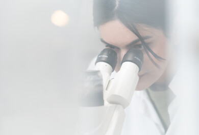 A person working in a laboratory with a microscope