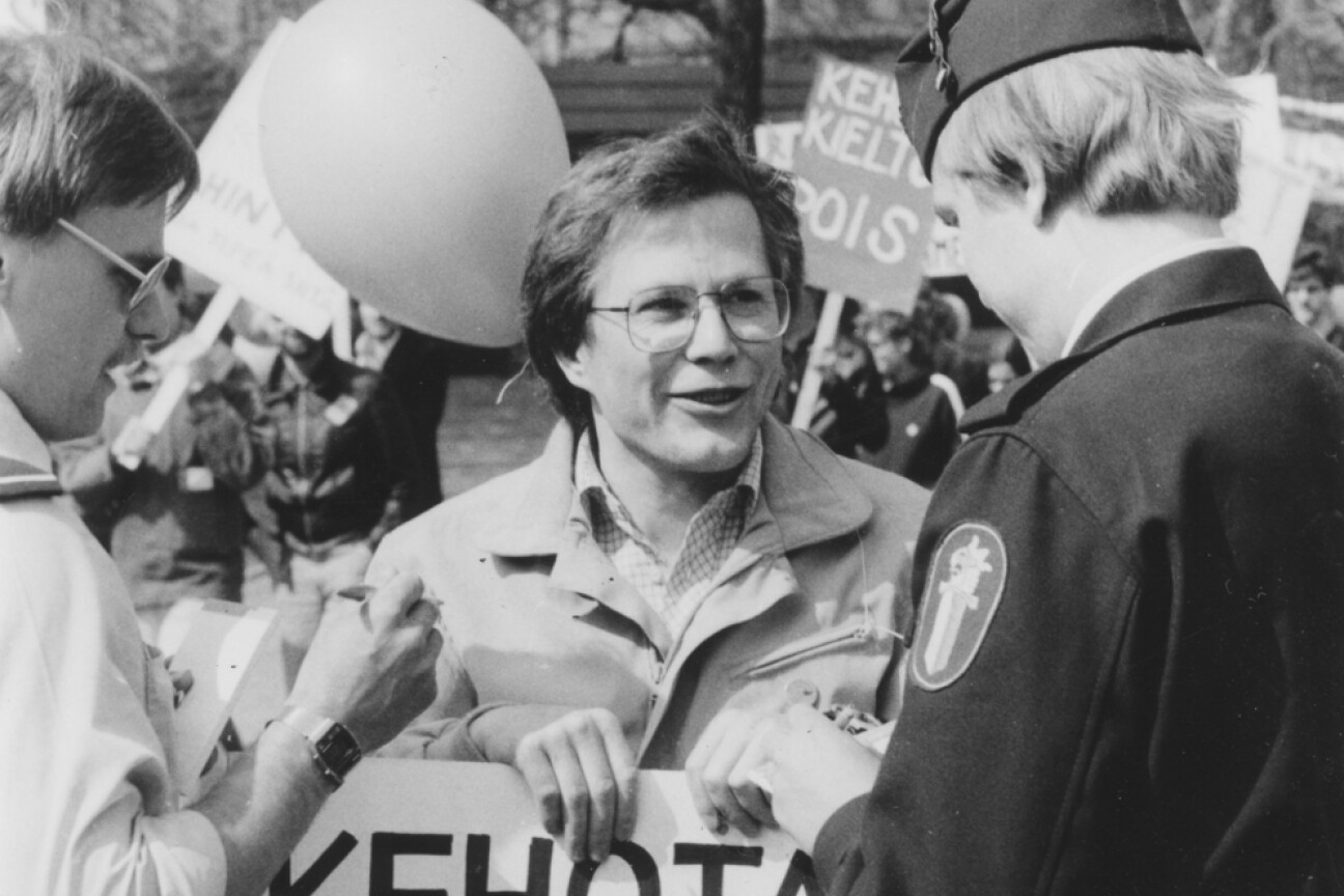Mustavalkoinen kuva, jossa mies, jolla on kyltti "Kehotan homoseksuaalisuuteen". Kaksi poliisia seisoo hänen edessään ja kirjoittaa.