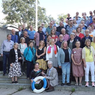 Joukko 60 sitten valmistuneita poseeraamassa yliopistonmäellä