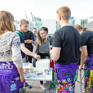 Students standing at a student organisation stall with organisation representatives